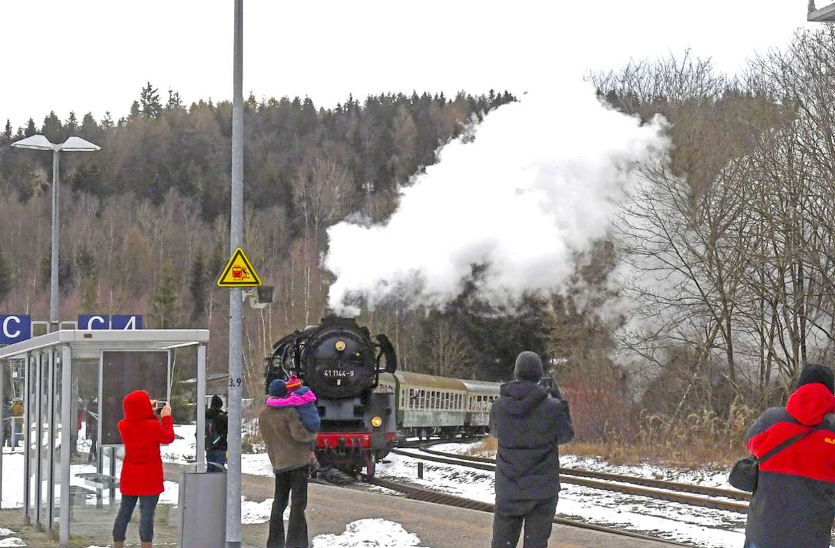Der Rodelblitz, dessen 84 Jahre alte Lok mächtig unter Dampf steht und sich schnaufend nähert,  wird von Schaulustigen am Bahnhof Zella-Mehlis erwartet.