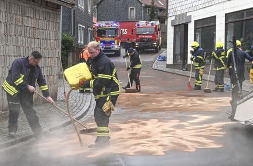Feuerwehrleute beim Beseitigen des ausgelaufenen Hydrauliköls von der Straße. Rechts im Bild der beschädigte Gabelstapler. Foto: frankphoto.de/K.-H. Frank