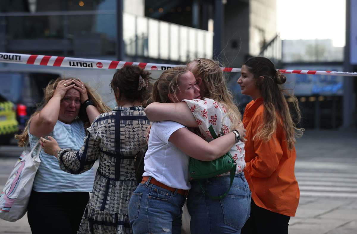Menschen trösten einander vor dem Einkaufszentrum Field’s. Foto: dpa/Olafur Steinar Gestsson