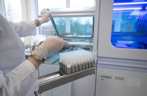Ein Träger mit Corona-Proben wird in einen Automaten für PCR-Tests gestellt. Foto: dpa/Sebastian Gollnow