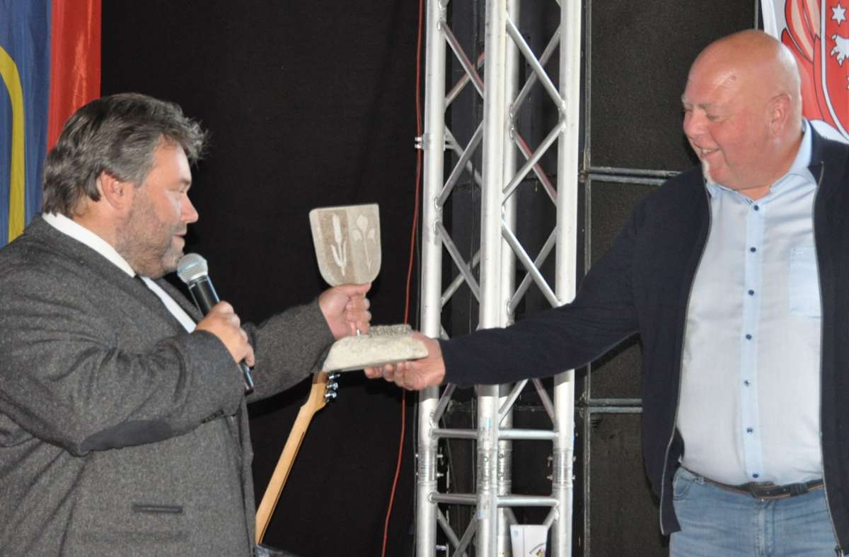 Gastgeschenk mit großer Symbolkraft: Bürgermeister Fabian Giesder (links) überreicht an seinen Amtskollegen Thomas Pinter einen Stein, in den beide Meiningen-Wappen  gemeißelt sind.