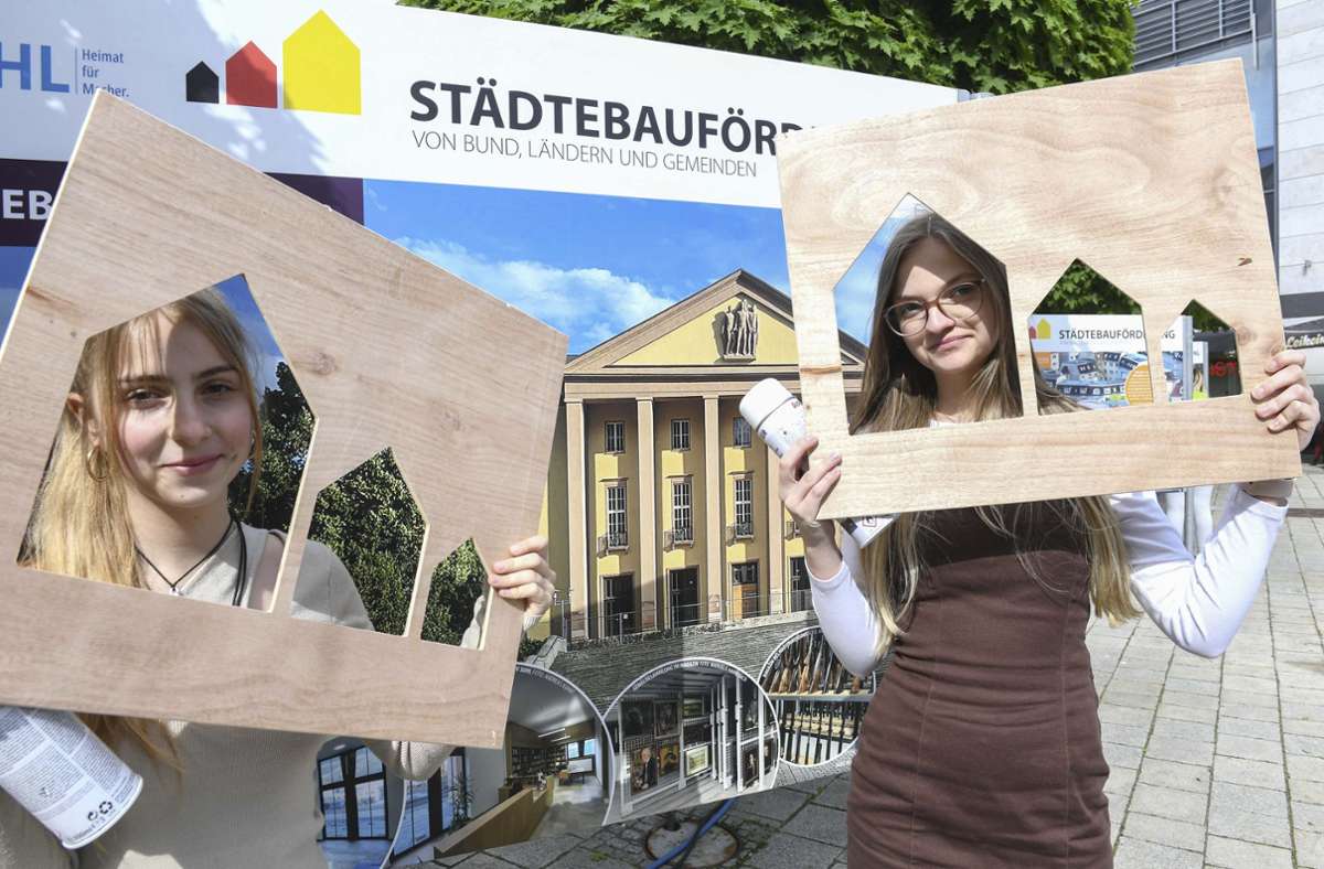 Meggi Szywak und Nele Fucke präsentieren ihre  Schablonen vor der Ausstellung zur Städtebauförderung am Dianabrunnen.