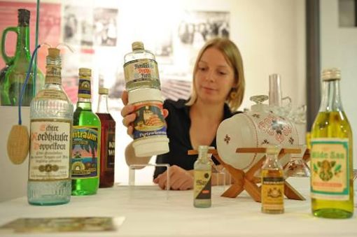 Die Kuratorin Teresa Thieme hält in der Ausstellung "Trinkkultur in der DDR" im Stadtmuseum Jena eine Flasche des Sets "Harzer Partygedeck" in der Hand. Foto: dapd