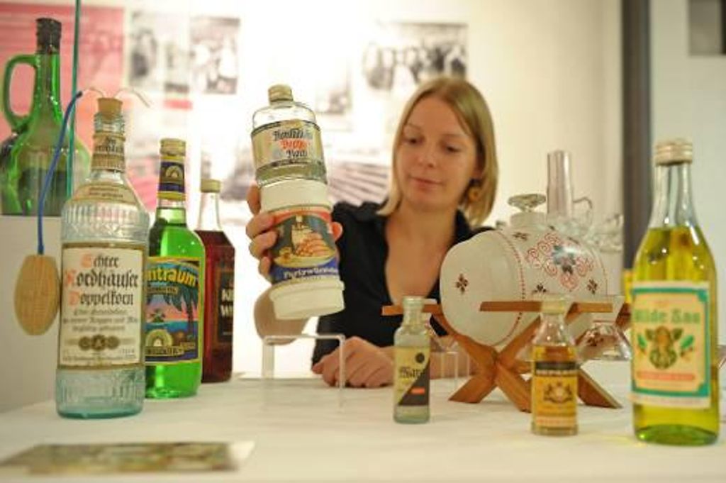 Die Kuratorin Teresa Thieme hält in der Ausstellung "Trinkkultur in der DDR" im Stadtmuseum Jena eine Flasche des Sets "Harzer Partygedeck" in der Hand. Foto: dapd