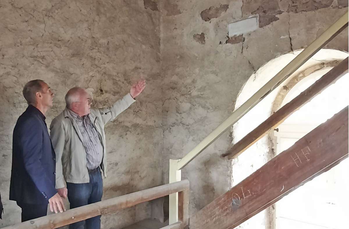Dr. Thorsten Brokmann vom Förderverein (rechts) macht  SPD-Bundestagsabgeordneten Frank Ullrich bei seinem Besuch im Kirchturm auf die Markierungen („Pflaster“) aufmerksam, mit denen die Risse im Mauerwerk genau beobachtet werden.