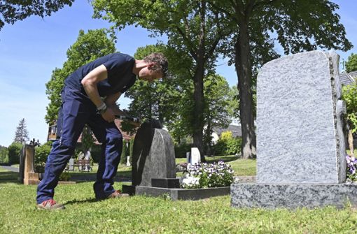 Auf dem Friedhof in Wallrabs fällt TÜV-Prüfer Ken Hauser ein wackliger Grabstein auf. Um seine genaue Standfestigkeit zu messen, benutzt er einen Foto: /Bastian Frank