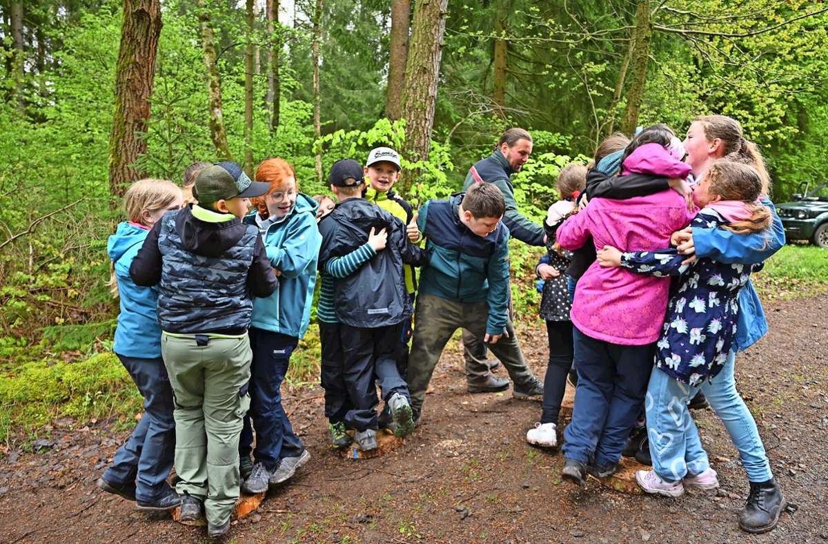 Vier Baumscheiben und 18 Kinder – kein Fuß durfte unten bleiben: Eine der Aufgaben im Wald.