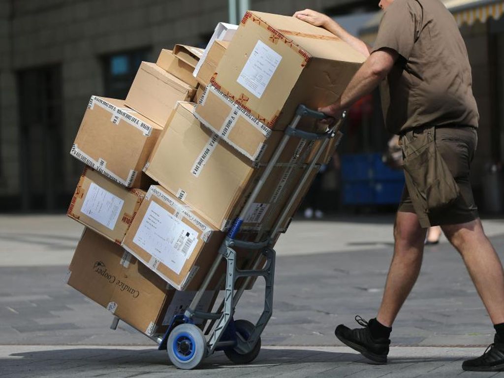 Ein Paketbote liefert Pakete aus. Symbolbild. Foto: Oliver Berg/dpa