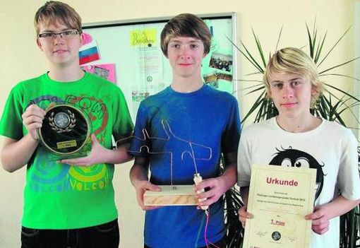 Johannes Schneider, Julien Hauck und Christoph Schäfer (v. l.)präsentieren ihren Pokal, das Modell und die Siegerurkunde. Foto: Erik Hande