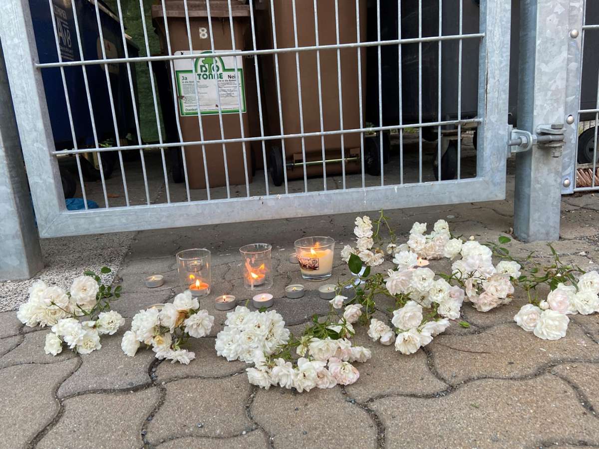 Anwohner stellten vor dem polizeilich versiegelten Müllplatz Kerzen auf. Der Pfarrer des Ortes brachte Blumen.