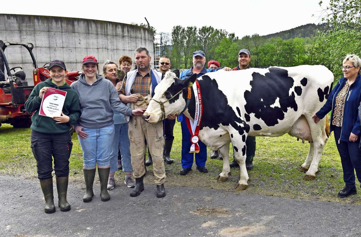 Stallleiterin Michaela Luthardt (rechts) mit ihrem Team und Kuh Tina, die in ihrem elfjährigen Leben bereits 100 000 Liter Milch lieferte. Es ist bereits das achte Tier in der Agrargenossenschaft Schalkau, das dafür prämiert wurde. Foto: Carl-Heinz Zitzmann