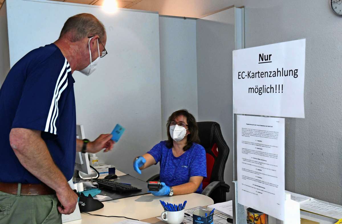 Monika Werner nimmt im Testzentrum die EC-Karte eines Bürgers entgegen. Nur damit kann derzeit gezahlt werden. Foto: Karl-Heinz. Frank Foto:  