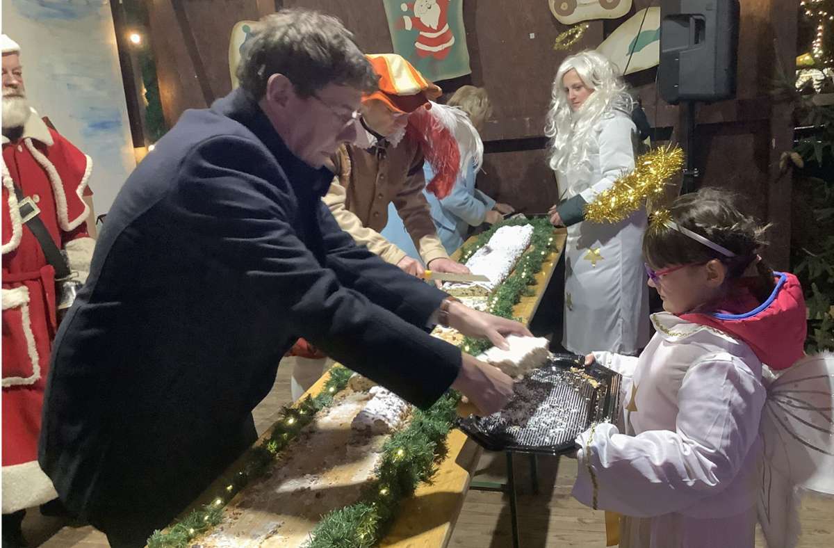 Bürgermeister Thomas Kaminski verteilt gemeinsam mit den Weihnachtsengeln den Stollen.