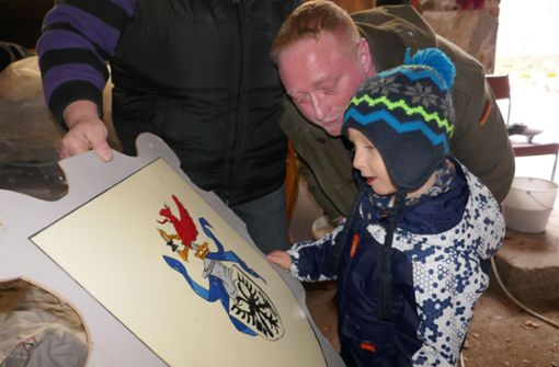 Der vierjährige Fritz Meinhardt suchte sich mit seinem Papa das Gehrener Wappenschild aus. Es findet an seiner Spielhütte im Garten einen neuen Platz. Foto: Karl-Heinz Veit