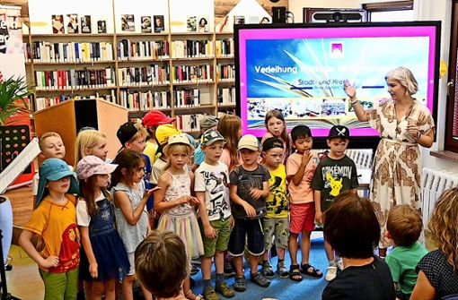 Kindergartenkinder berichteten mit Cornelia Schmädicke (rechts)  im Bibliothekslied von der Entdeckung der Buchausleihe Foto: Erik Hande