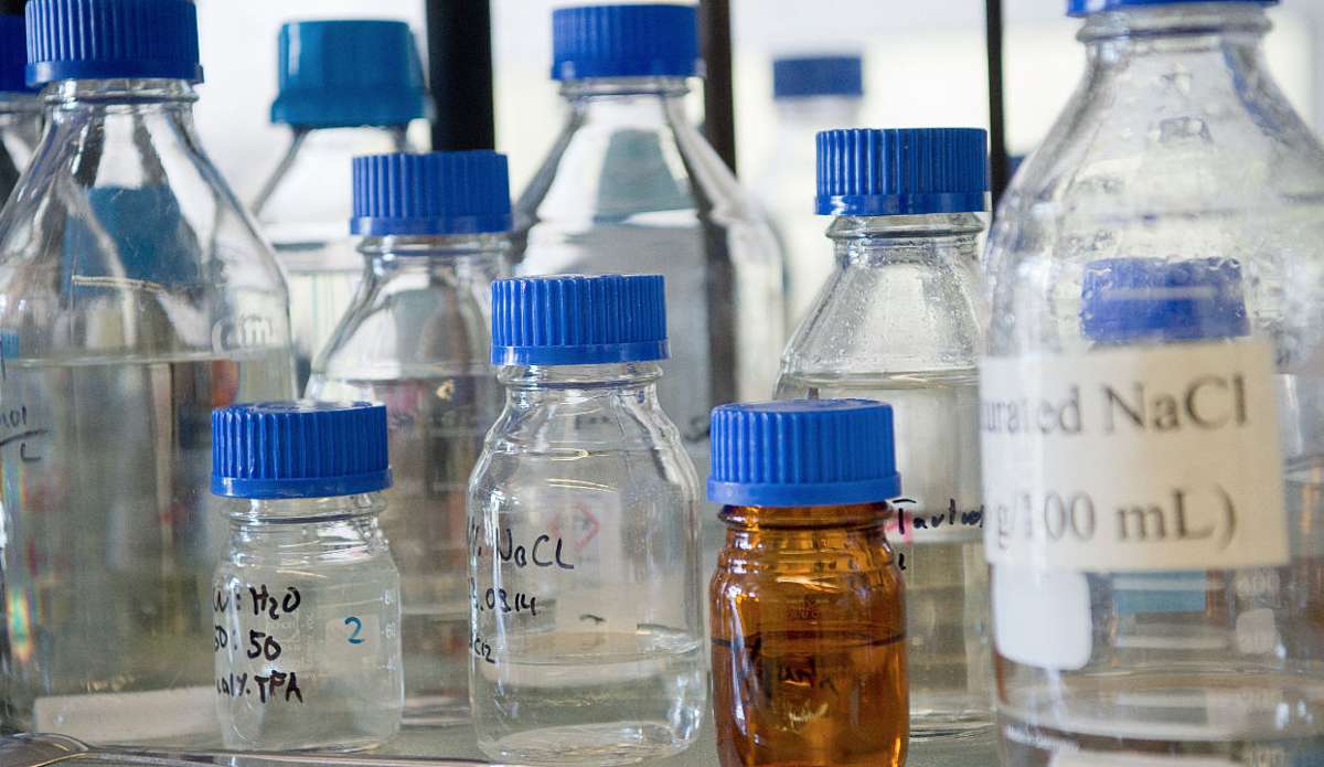 Flaschen mit Chemikalien stehen auf einem Tisch in einem Labor (Symbolfoto). Foto: Archiv/dpa