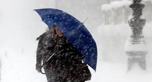 Eine Frau kämpft sich durch heftiges Schneetreiben. Foto: dpa
