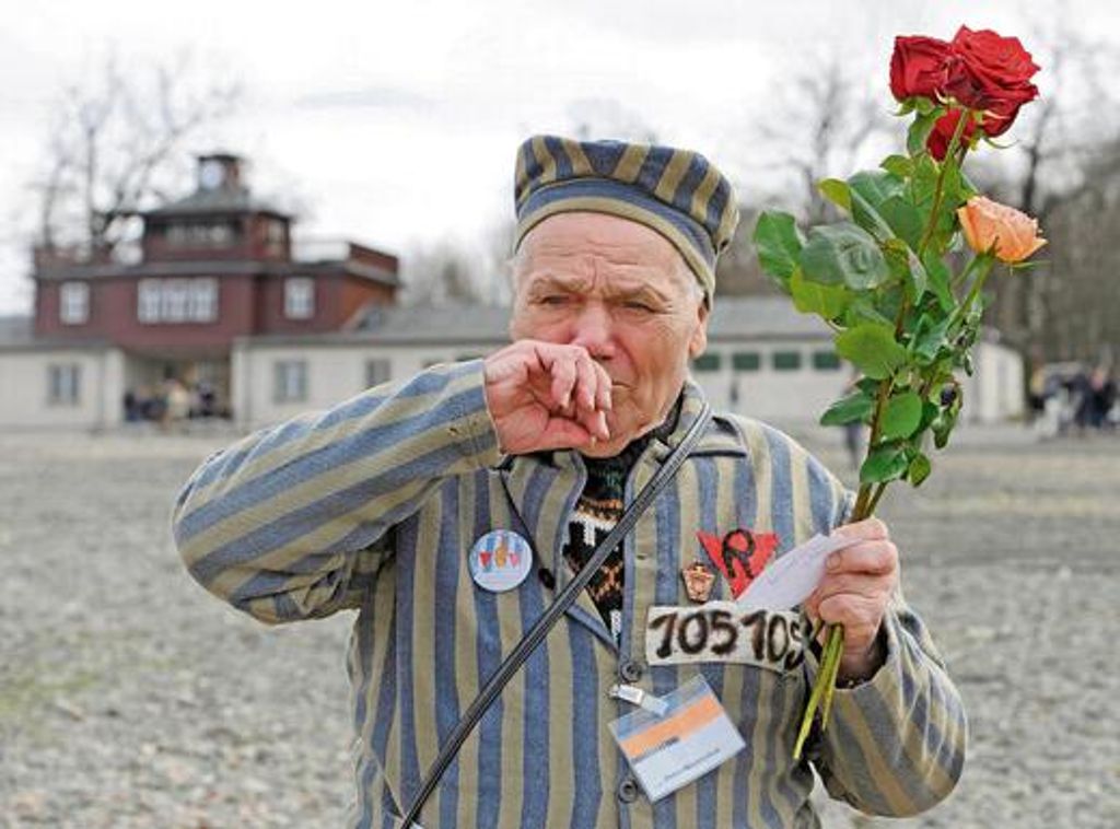 In der KZ-Gedenkstätte Buchenwald geht der ehemalige Häftling Petro Mischtschuk aus Kiew (Ukraine) mit Rosen über den früheren Appellplatz. Foto: AP