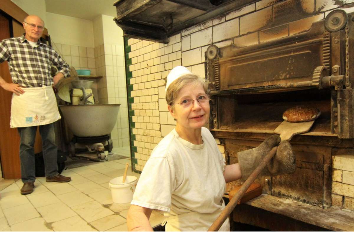 Ilka und Bernd Stay an ihrem museal anmutenden altdeutschen Steinbackofen mit Brustfeuerung. Besonders wie der um 1900 gesetzte Ofen sind auch die Brote, die darin gebacken werden.