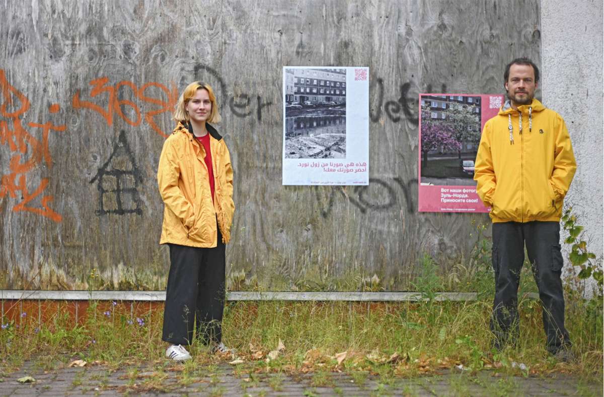 Carlotta Steinkamp und Rafael Brix mit Plakaten an einem Bauzaun, die zum Straßenfest