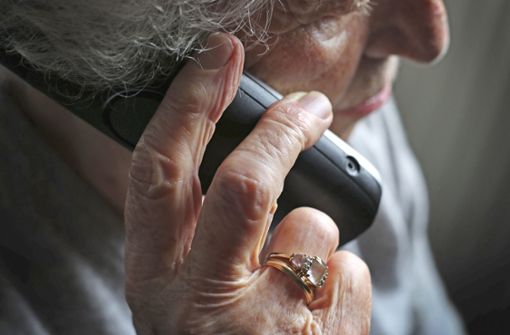 Eine ältere Frau telefoniert mit einem Festnetztelefon. Viele Seniorinnen und Senioren werden durch den so genannten Enkeltrick oder Schockanruf um ihr Erspartes gebracht. Foto: dpa