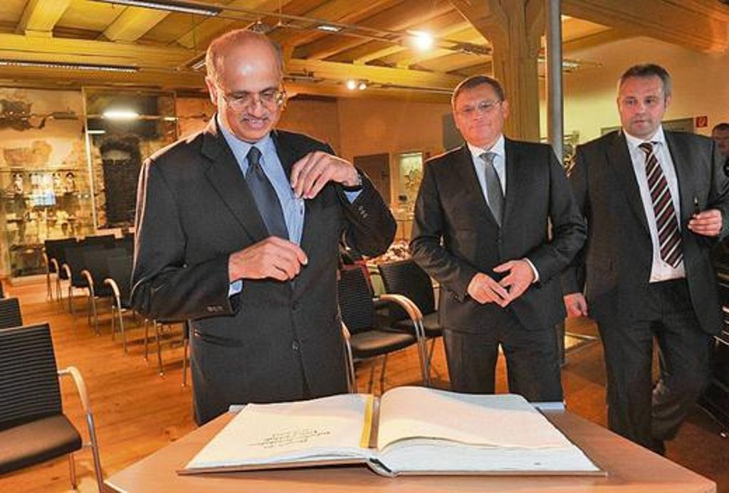 Den Stift gezückt: Indiens Botschafter Vijay Gokhale trägt sich im Beisein von Wirtschaftsminister Uwe Höhn (Mitte) und Bürgermeister Holger Obst (rechts) ins Goldene Buch der Stadt Hildburghausen ein.