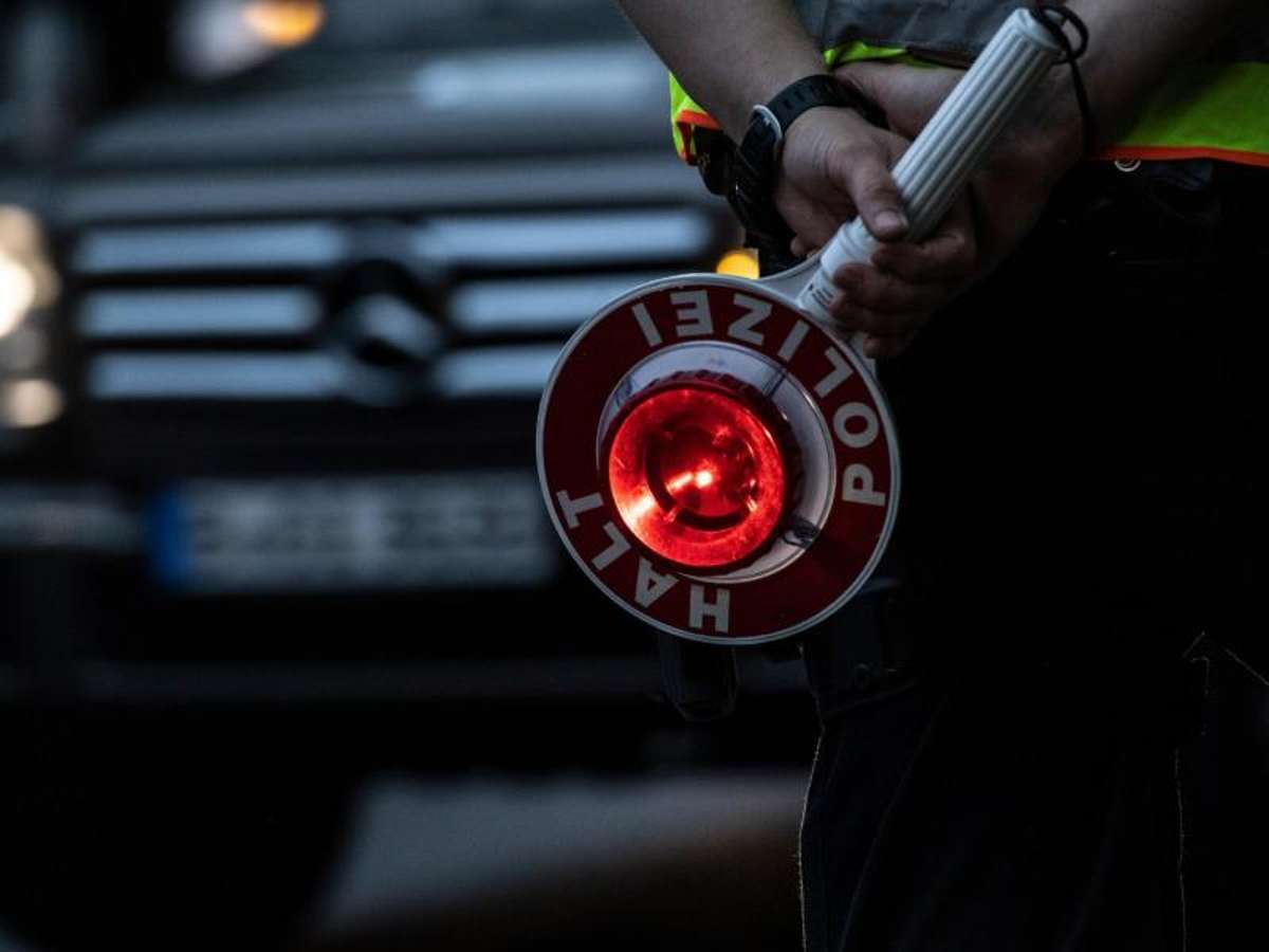 Ein Polizist hält bei einer Verkehrskontrolle eine Winkerkelle in der Hand. - Symbolfoto Foto: Paul Zinken/dpa