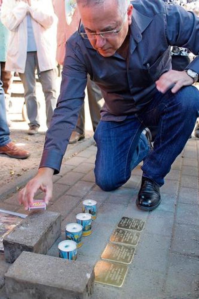 Dany Aharon, der aus Israel nach Barchfeld gekommen war, zündet neben den Stolpersteinen Kerzen für seine Familie an. Gestiftet wurden die Steine vom Heimat- und Geschichtsverein, von Ingo Schäfer und der Gemeinde Barchfeld.