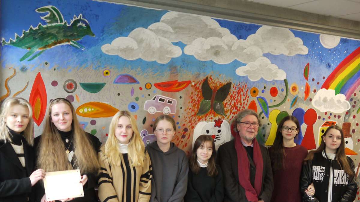 Der Künstler Gerhard Renner mit den Schülerinnen der Bürgerschule  vor dem von ihnen gestalteten individuellem Wandbild mit Hinweisen zur Spielzeuggeschichte der Stadt.