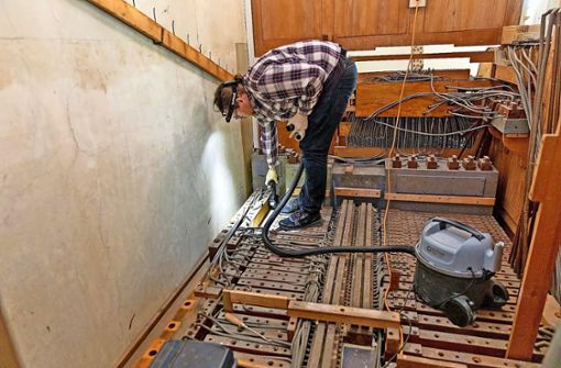 Orgelbauer Marco Ellmer reinigt die Windladen  und baut sie aus. Durch die vielen Röhren sieht es im Innern der Orgel wie in einer Maschine aus. Foto:  
