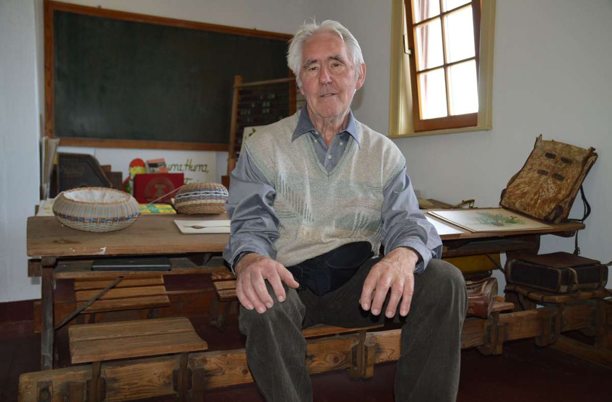 Bernd Ebert (81) sitzt noch einmal auf einer der alten Schulbänke, wie er sie als Schüler selbst gedrückt hat. Im Heimatmuseum gibt es    ein Schulzimmer mit Utensilien von anno dunnemals.