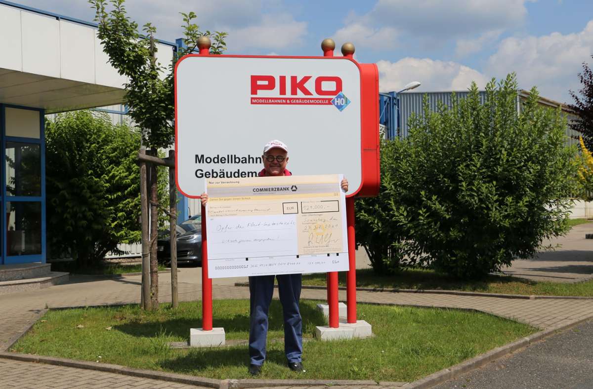 Piko-Chef René F. Wilfer mit dem symbolischen Scheck vorm Werk in Oberlind. Foto: /Privat