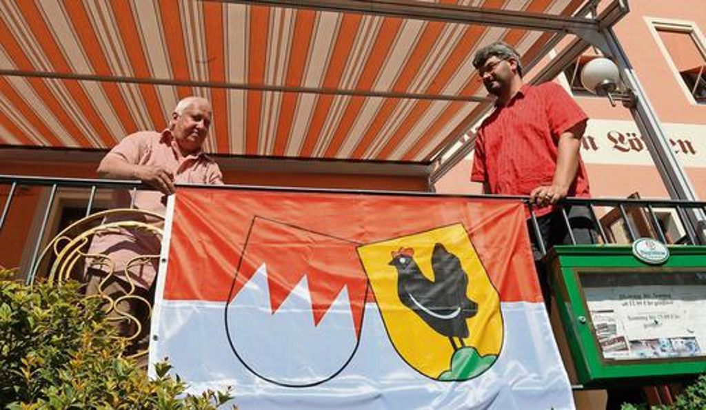 Lothar Beck und Martin Truckenbrodt beim Anbringen der Henneberg-Franken-Fahne auf dem Schleusinger Markt.	Foto: frankphoto.de Quelle: Unbekannt