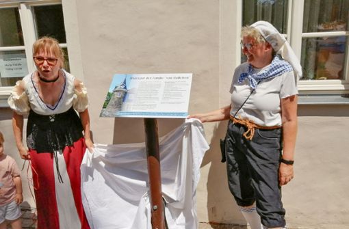 Gabriela Jahn (links) und  Sylvia Himmelreich entfernen das Tuch von der neuen  Geschichtstafel am Edelhof. Foto: Marina Hube