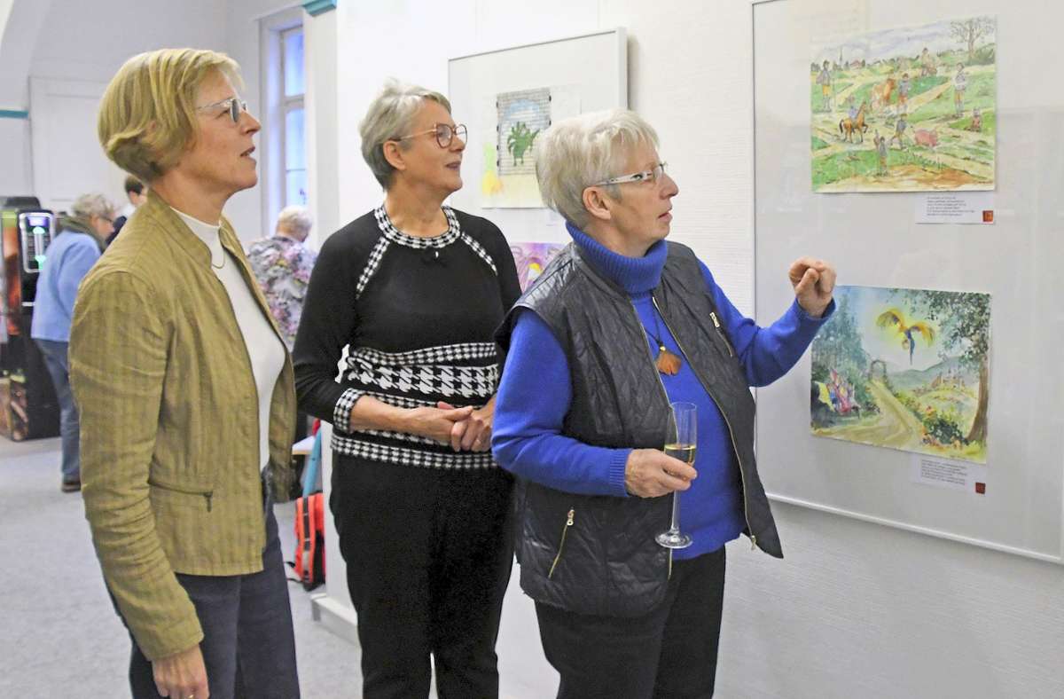 Bibliothekschefin Andrea Feldt, Gerlinde Simchen, Leiterin des Malzirkels, und Uta Kessel (von links) betrachten die Märchenbilder. Foto: Berit Richter