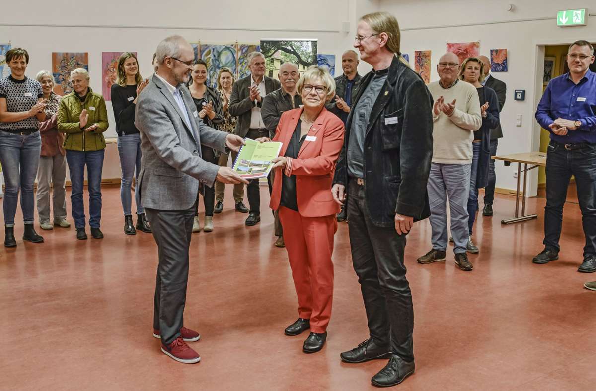 Tobias Preising  (links) vom Planwerk Nürnberg überreicht Sylke Niebur,   Beigeordnete im Landratsamt Gotha, und Kay Tischer,  Beigeordneter des Ilm-Kreises,  die neue Regionale Entwicklungsstrategie 2023 bis 2027. Foto:  