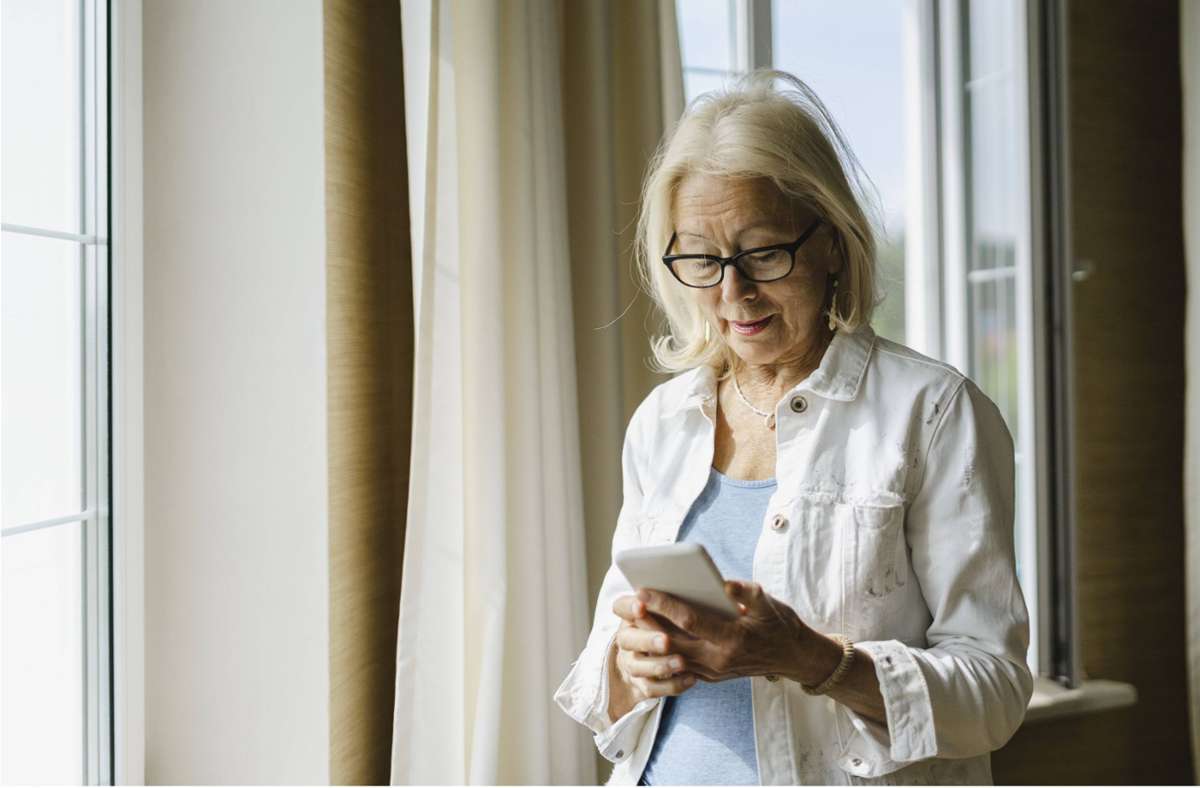 Eine Seniorin mit einem Handy (Symbolbild). Foto: IMAGO/Westend61/IMAGO/Evgenia Sunegina